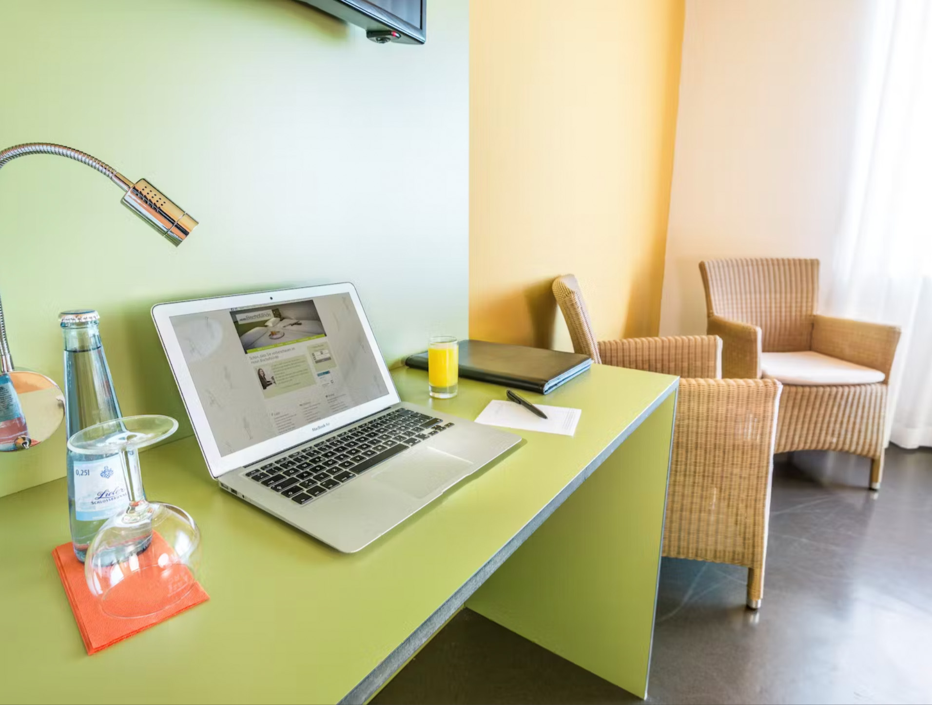 Limettengrüner Tisch mit Getränken und Laptop am Fenster mit Tageslicht