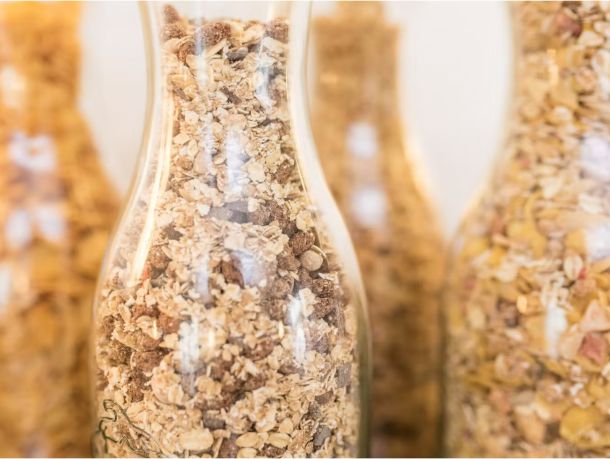Vier Glas-Karaffen mit verschiedenen Müsli-Sorten