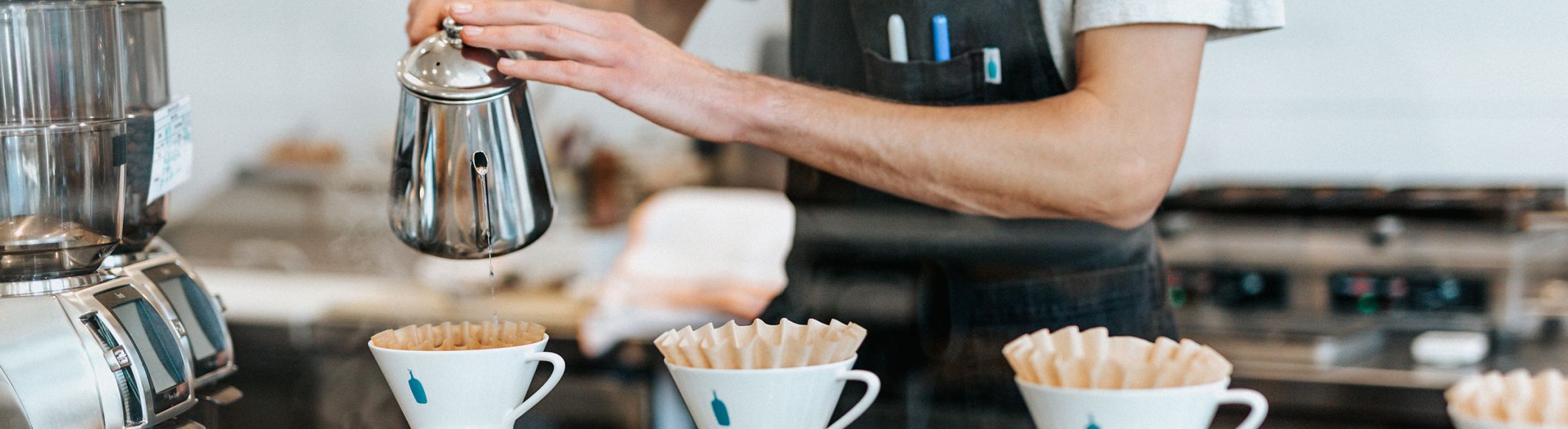 Kaffee wird von einem Mitarbeiter aufgegossen.