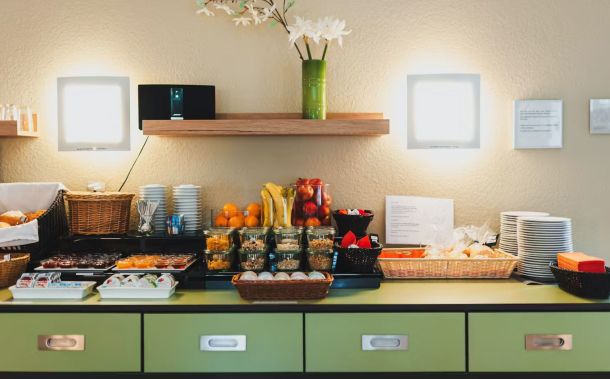 Buffet mit frischen Orangen, Bananen, Äpfeln, Nüssen und Brötchen