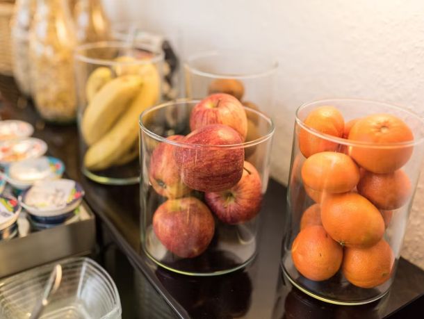 Glas-Schalen mit einer Auswahl an frischem Obst am Frühstücksbuffet.